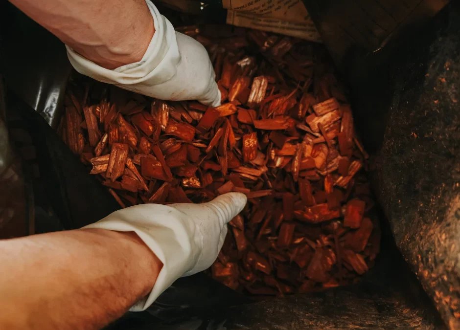 A man mulching garden with wood chips